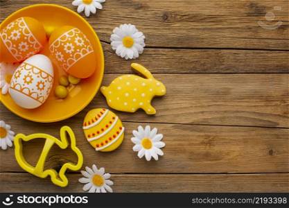 top view colorful easter eggs plate with chamomile flowers copy space