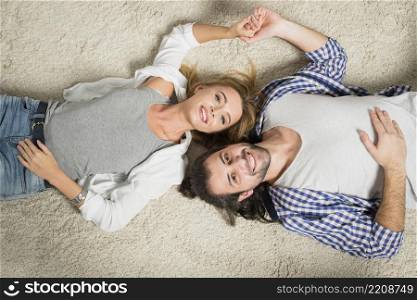 top view couple portrait laying carpet
