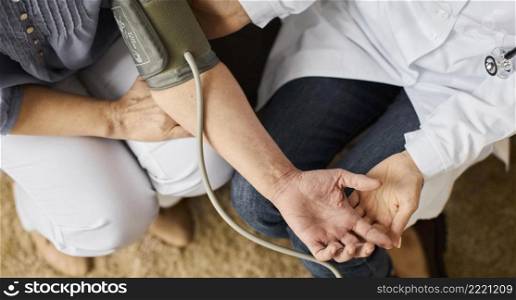 top view covid recovery center female doctor checking elder patient s blood pressure