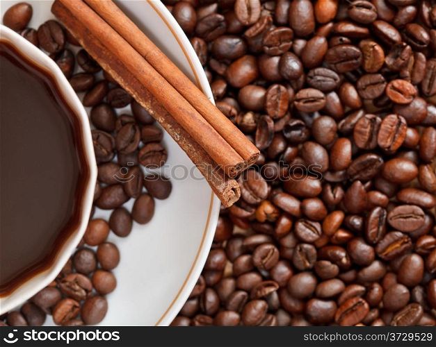 top view cup of coffee and roasted coffee beans with cinnamon close up