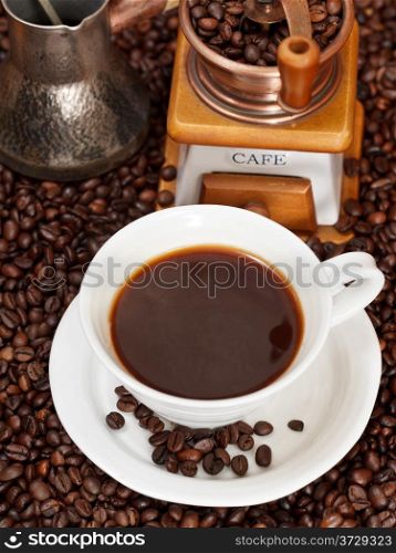 top view cup of coffee and roasted coffee beans with retro manual mill, coffee pot