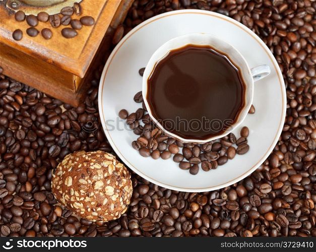 top view cup of coffee and roasted coffee beans with retro wooden manual mill with biscuit