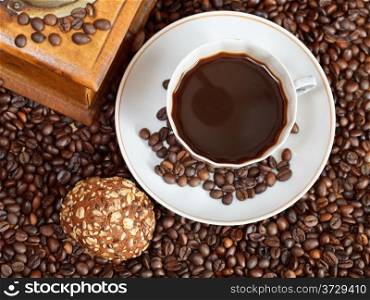 top view cup of coffee and roasted coffee beans with retro wooden manual mill with biscuit