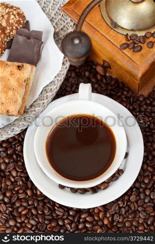 top view cup of coffee and roasted coffee beans with retro wooden manual grinder, biscuit