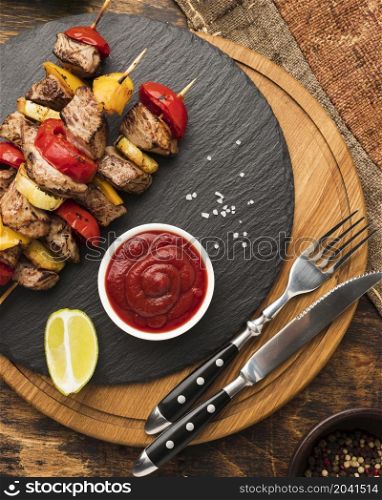 top view delicious kebab slate with ketchup cutlery
