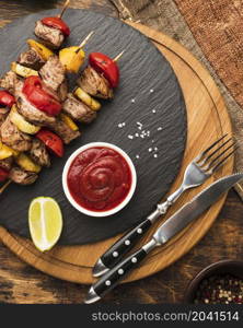 top view delicious kebab slate with ketchup cutlery