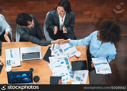 Top view diverse coworker celebrate with handshake and teamwork in corporate workplace. Happy business people handshaking after successful meeting or business presentation on data analysis. Concord. Top view diverse coworkers celebrate success with handshake. Concord