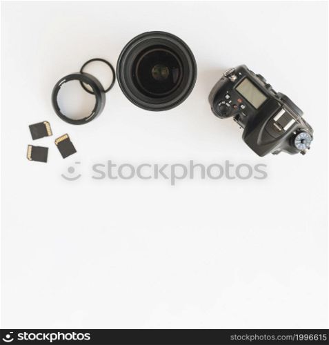 top view dslr camera memory cards camera lens with extension rings white backdrop