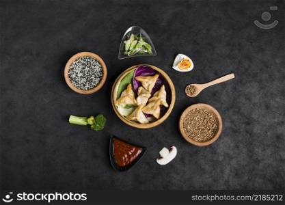 top view dumplings steamers surrounded with sesame sauce coriander seeds broccoli mushroom black background
