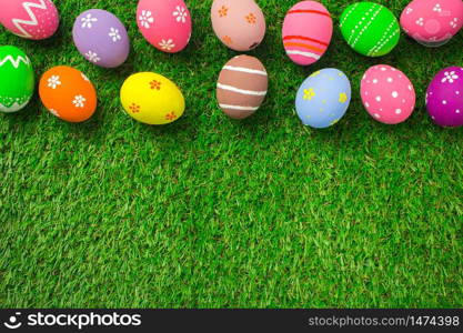 Top view easter egg painting colorful during the Easter and artificial grass green. Easter eggs on the green grass.