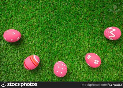 Top view easter egg painting colorful during the Easter and artificial grass green. Easter eggs on the green grass.