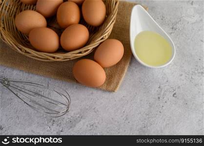 Top view eggs on sack cloth, many eggs on wicker basket and glasses bowl, oil and egg whisk placed on the floor, preparing for cooking food or dessert,©  space