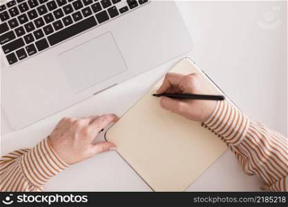 top view female teacher writing something using laptop during online class