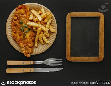 top view fish chips plate with chalkboard cutlery