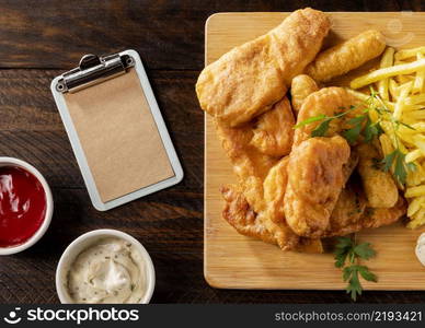 top view fish chips with clipboard sauces