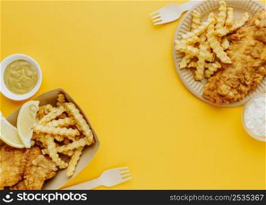 top view fish chips with sauces forks