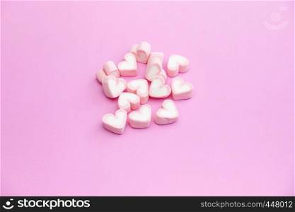Top view flat lay design of colorful pastel candy color of heart shaped marshmallow on pink background with copy space design for web banner template, brochure, background, wallpaper, menu restaurant