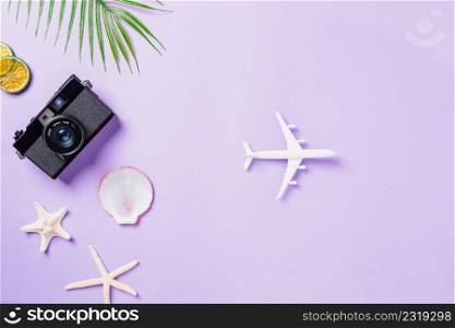 Top view flat lay mockup of retro camera films, airplane, shells, starfish beach traveler accessories on a purple background with copy space, Business trip, and vacation summer travel concept