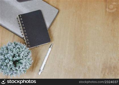 Top view flat lay notebook and flower and pen on wood table.Copy space