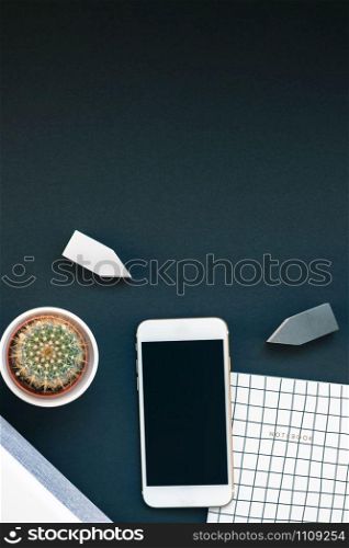 Top view flat lay of feminine desk workspace with white stereo bluetooth soundbar and smartphone for music listening with copy space on black background. Template for blog social media