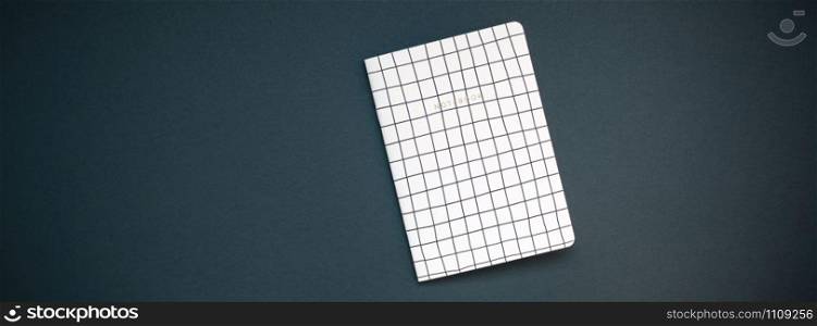 Top view flat lay of pattern notepad with copy space on black color paper background in minimal style. Template for feminine blog social media