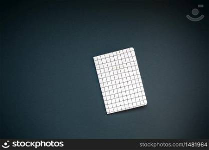 Top view flat lay of pattern notepad with copy space on black color paper background in minimal style. Template for feminine blog social media