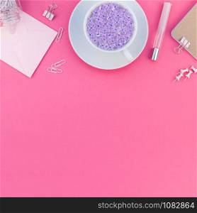 Top view flat lay of workspace desk styled design office supplies and cup of tea with copy space on a bright pink color paper background minimal style. Square Template for feminine blog social media