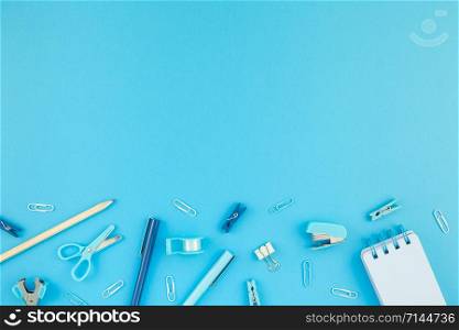 Top view flat lay of workspace desk styled design school and office supplies with copy space turquoise blue color paper background minimal style. Template for feminine blog social media