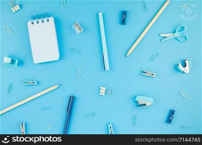 Top view flat lay of workspace desk styled design school and office supplies with copy space turquoise blue color paper background minimal style. Template for feminine blog social media