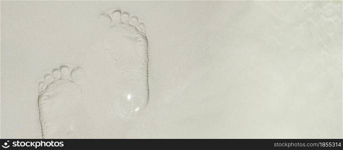 top view footprint on sand at sea beach in summer day.vacation banner background