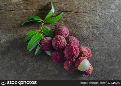 top view fresh Lychee with leaves over wooden background. Lychee fruit