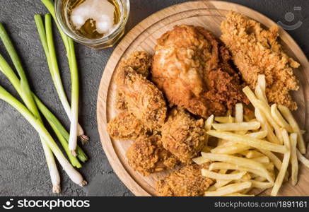 top view fried chicken with fries cutting board green onions. Resolution and high quality beautiful photo. top view fried chicken with fries cutting board green onions. High quality and resolution beautiful photo concept