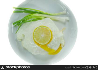 top view fried egg with fresh vegetable and slice lime on dish over white background