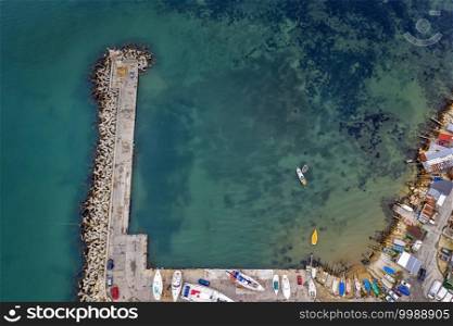 Top view from drone to the pier and the marina with boats and yachts. Sea landscape with fishing houses from above