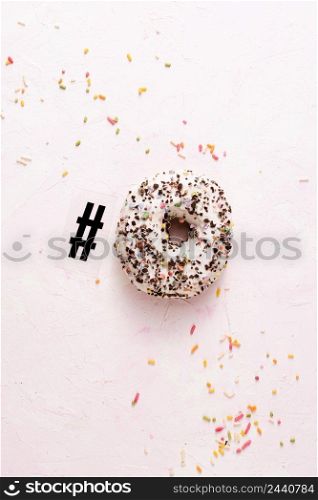 top view glazed doughnut with sprinkles hashtag symbol