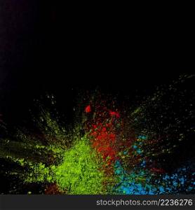 top view green blue red holi colored powder black background