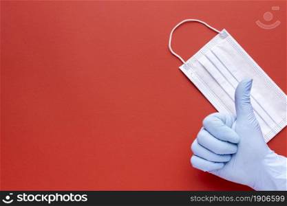 top view hand giving thumbs up with medical mask copy space. High resolution photo. top view hand giving thumbs up with medical mask copy space. High quality photo