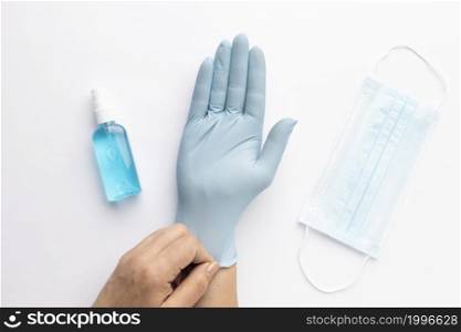 top view hand putting glove with hand sanitizer medical mask 1