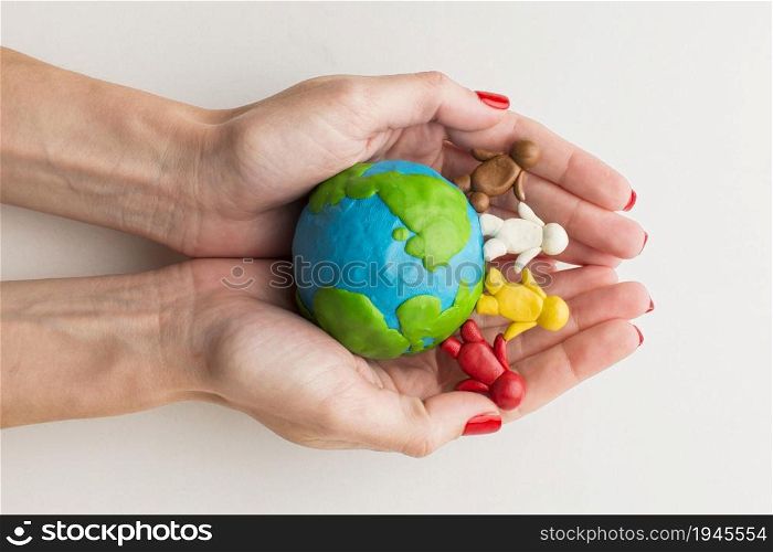 top view hands holding plasticine globe people. High resolution photo. top view hands holding plasticine globe people. High quality photo