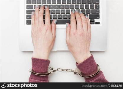 top view hands with handcuffs working laptop
