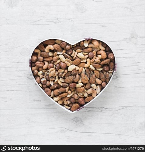 top view healthy dryfruits heart shape wooden desk. High resolution photo. top view healthy dryfruits heart shape wooden desk. High quality photo