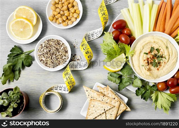 top view hummus with assortment vegetables measuring tape. Resolution and high quality beautiful photo. top view hummus with assortment vegetables measuring tape. High quality and resolution beautiful photo concept