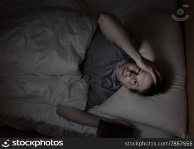 Top view image of mature man, looking forward, having trouble sleeping from insomnia