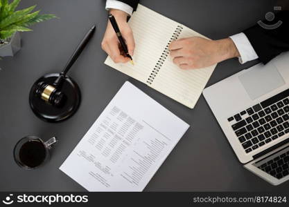 Top view lawyer or judge working on his desk with laptop at law firm or court, drafting legal documents with fairness and ethical judgment for lawsuits and litigation. Equilibrium. Top view lawyer working on his desk with laptop at law firm. Equilibrium