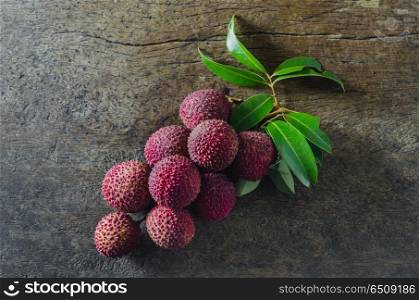top view Lychee with leaves on a wooden background. Lychee fruit