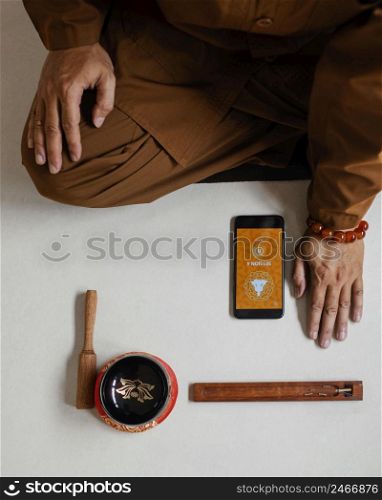 top view man meditating with singing bowl smartphone