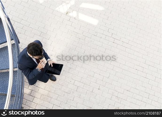 top view man with tablet drinking coffee