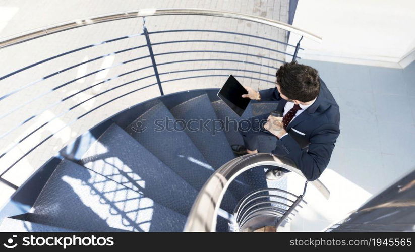 top view man with tablet standing stairs. High resolution photo. top view man with tablet standing stairs. High quality photo