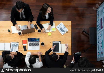 Top view manager or office worker give presentation in harmony conference room to business colleague, BI data dashboard on screen and pile of financial analyzed data reports on meeting table.. Top view business presentation at harmony conference room with colleagues.