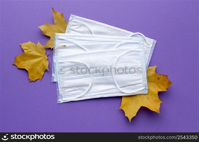 top view medical masks with autumn leaves
